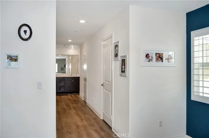 This long hallway leads to the en suite bath and has separate access doors to the dual closets on the side. Yes, there's more luxury vinyl plank flooring here.