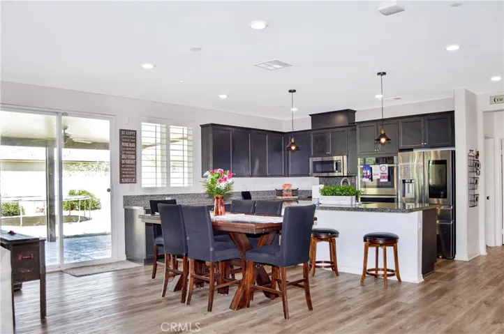 The dining area is perfectly located between the living area and the kitchen and offers access to the covered patio, backyard views, recessed lighting, and more of that luxury waterproof flooring