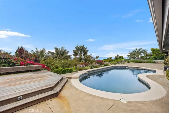 The inviting pool and spa sits next to an elevated deck.
