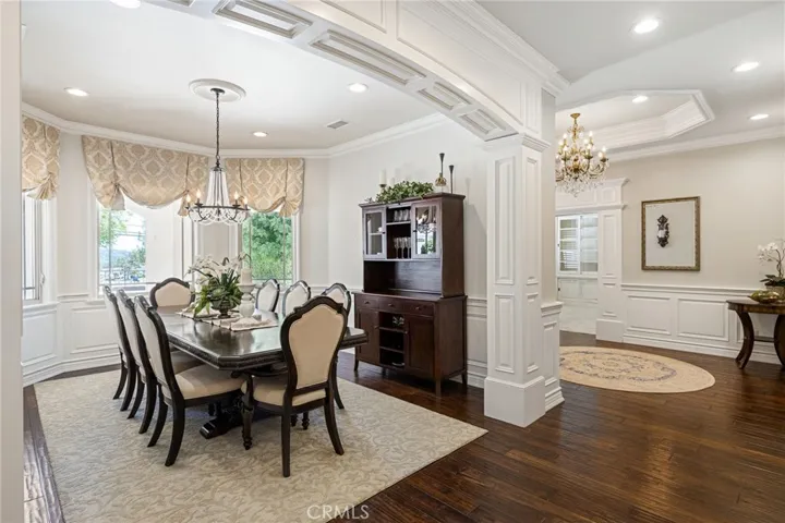 Formal dining room with custom paneling and arched entry.