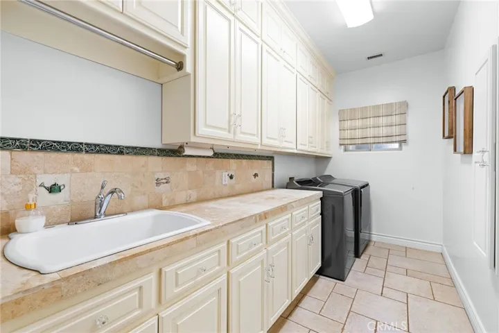 Oversized laundry room with plenty of storage and sink.