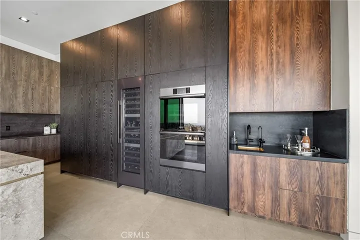 Entertainers Kitchen with full view over to dining room and living room.  Includes a hidden dishwasher, side by side hidden refrigerator and two hidden freezers.  Also includes a 100 bottle wine refrigerator.