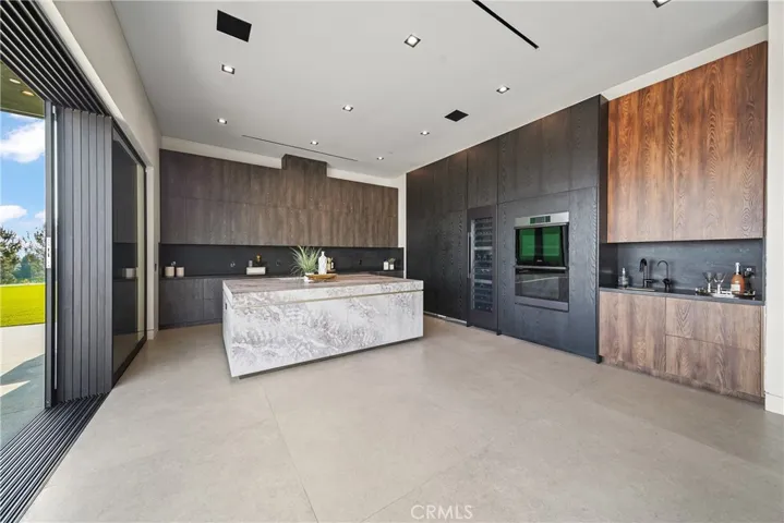 Entertainers Kitchen with full view over to dining room and living room.  Includes a hidden dishwasher, side by side hidden refrigerator and two hidden freezers.  Also includes a 100 bottle wine refrigerator.