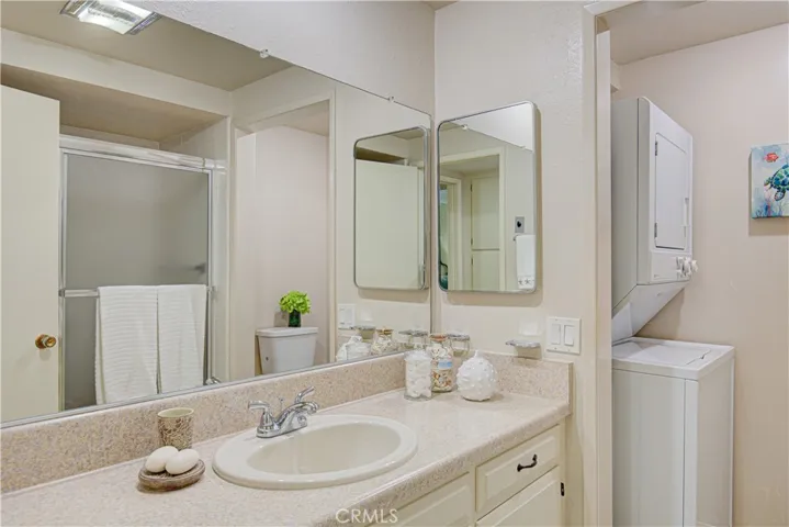 The secondary bathroom hosts the convenient inside stacked washer/dryer that is included in the sale.