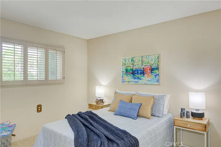 The secondary bedroom is light and bright with shutters.