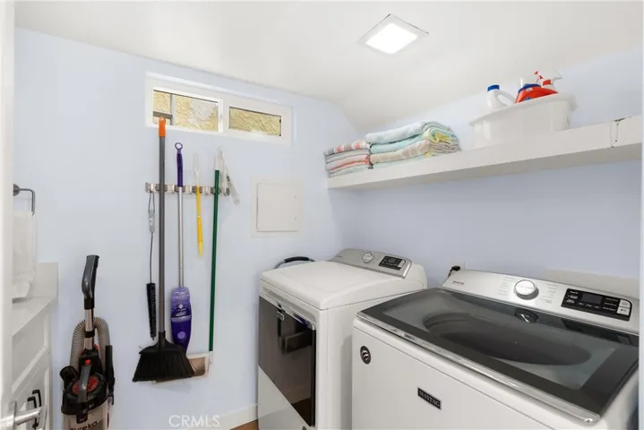 Full sized laundry room with sink, storage cabinetry & more.