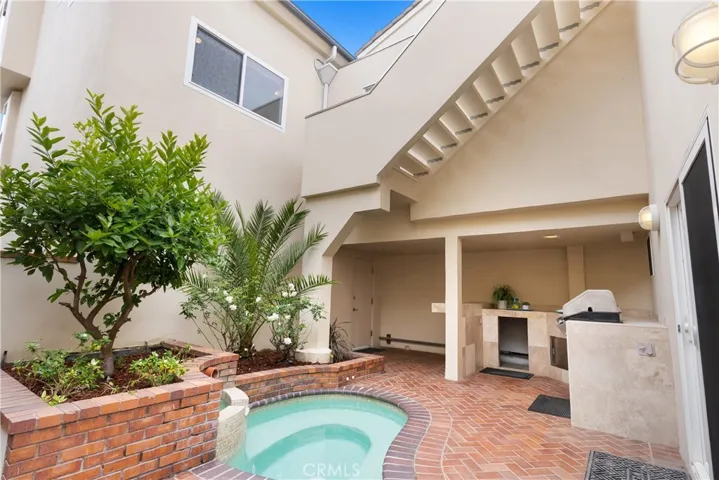 A secluded oasis with spa, built-in barbeque, sit up countertop, sink and storage.