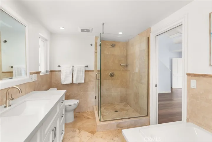 With dual sinks, custom tile work, large soaking tub and glass enclosed large shower.