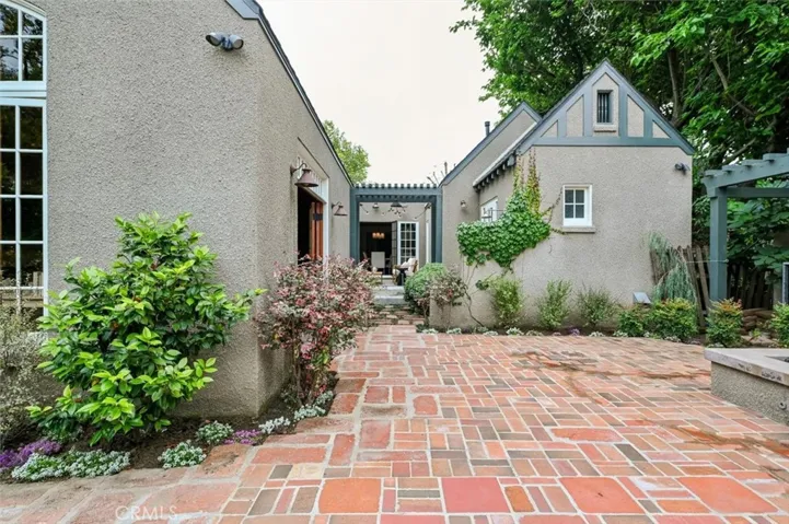 Looking from the garage back to the house. Love the patio with mismatched brick- very English garden.