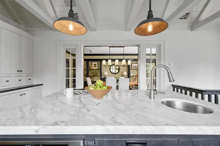 A large center island with stone counter and prep sink.