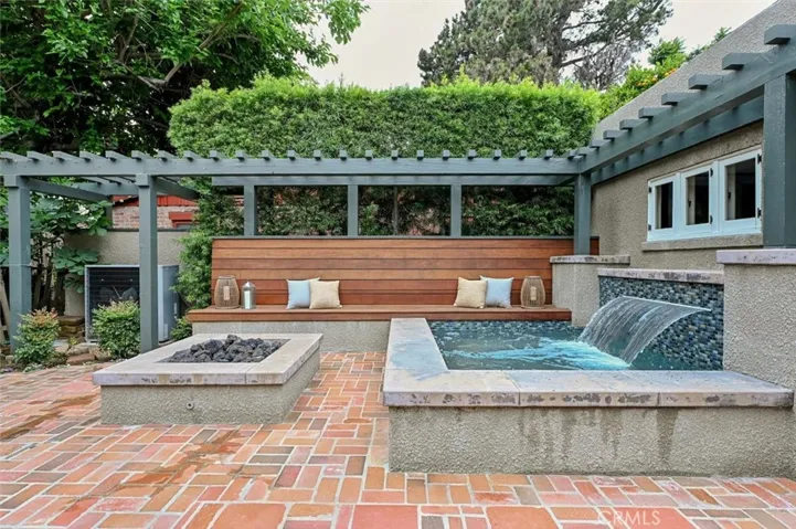 Backyard trellis frames the firepit and spa area.