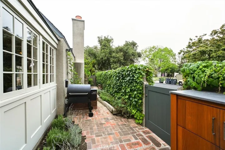 Gate to sidewalk and small garden area in kitchen garden.