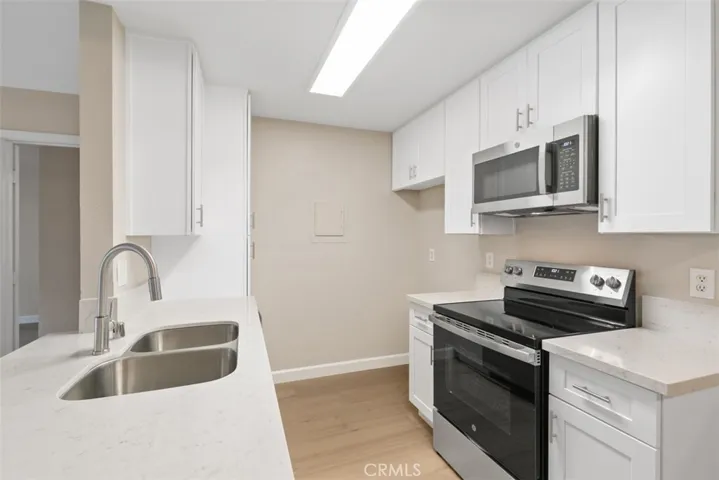 Beautiful kitchen with brand new range, dishwasher, microwave, double sink, quarts counters and cabinetry.