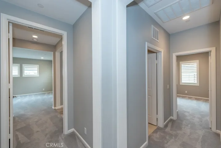 upstairs hall, looking into bedroom 3 on right, and upstairs laundry room door shown; looking left leads into 4th (primary) bedroom