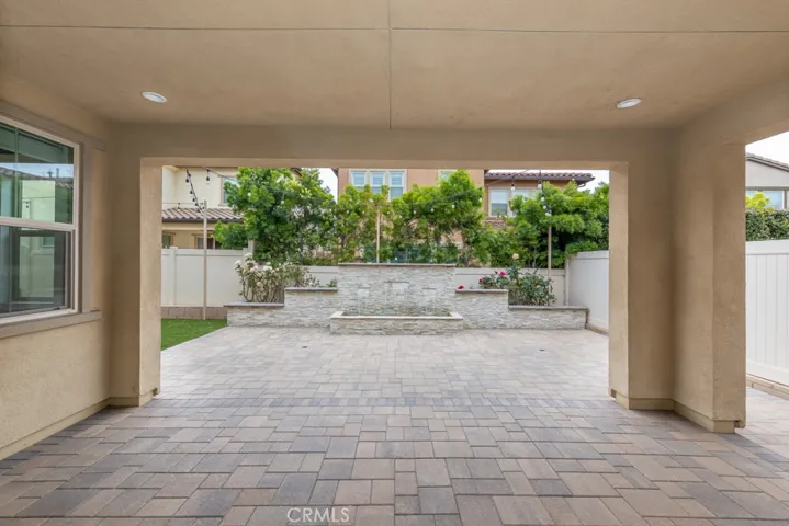 large covered patio with stunning water fountain and synthetic grass area