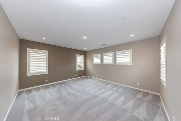 Primary bedroom at back of house overlooking backyard offers both lots of light and privacy shades