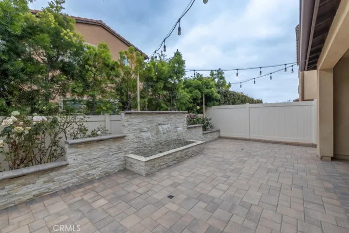 view of water feature (has recessed lights above waterfall) and rear planter