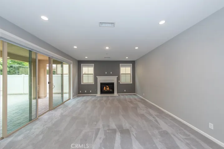 huge den with large double sliders leading to covered patio area of backyard