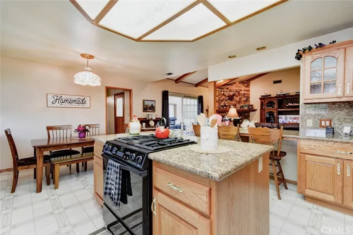 JENN AIR GAS COOKTOP AND LOWER CONVECTION OVEN.  EATING AREA IN KITCHEN AS WELL AS A BAR OVERLOOKING THE FAMILY ROOM