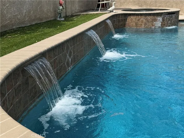 Backyard with remodeled pool, stucco block walls
