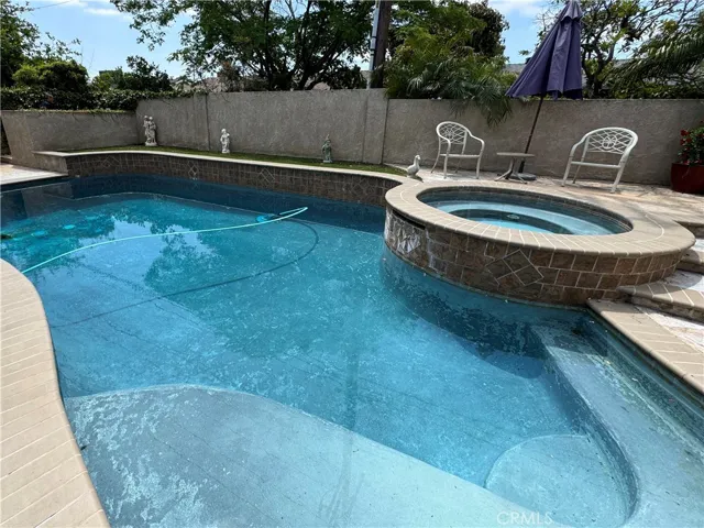 Backyard with remodeled pool, stucco block walls