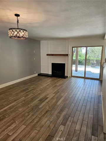 Dining area photo with fireplace, custom wood Mantel nd slider to large Patio with no one behind, just serene nature view