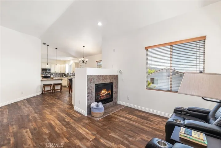 Enjoy cozy evenings by the fireplace in this spacious living area, seamlessly connected to a modern kitchen and dining space.