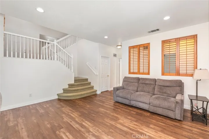 This spacious living area features ample natural light, and a welcoming staircase leading to the upper level.