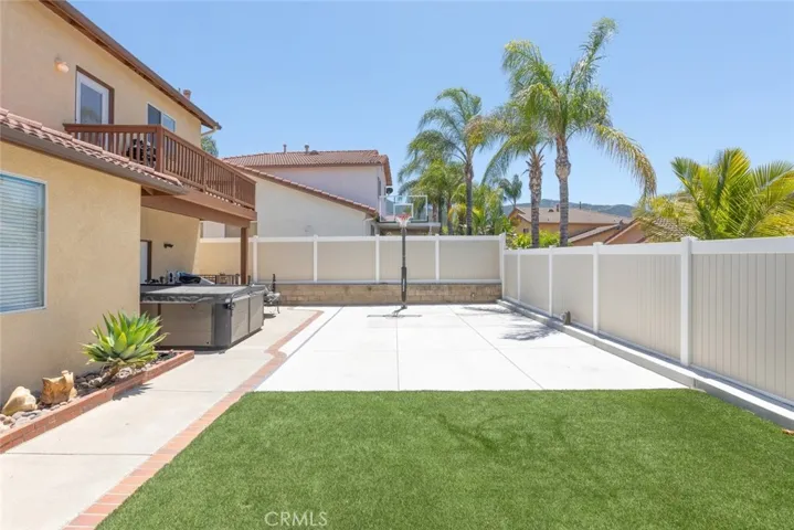 Enjoy endless fun and exercise in this backyard, complete with a basketball court and lush artificial grass.
