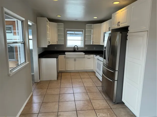 A large farmhouse sink is surrounded by abundant counter space with the perfect setup of dishwasher to sink to stove/oven to fridge