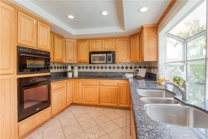 Updated kitchen with granite countertops, custom tile backsplash & recessed lighting~