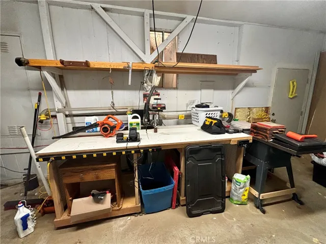 Workshop has two work benches, saws, tools and storage