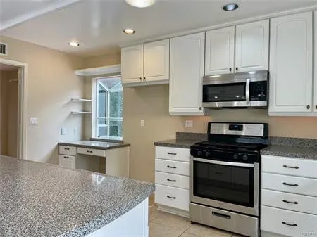 Spacious kitchen with a desk area by the window...
