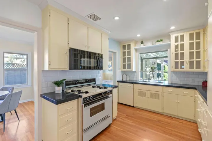 Upgraded Kitchen overlooking backyard, very bright, lots of storage, gas range, opens to Dining Room