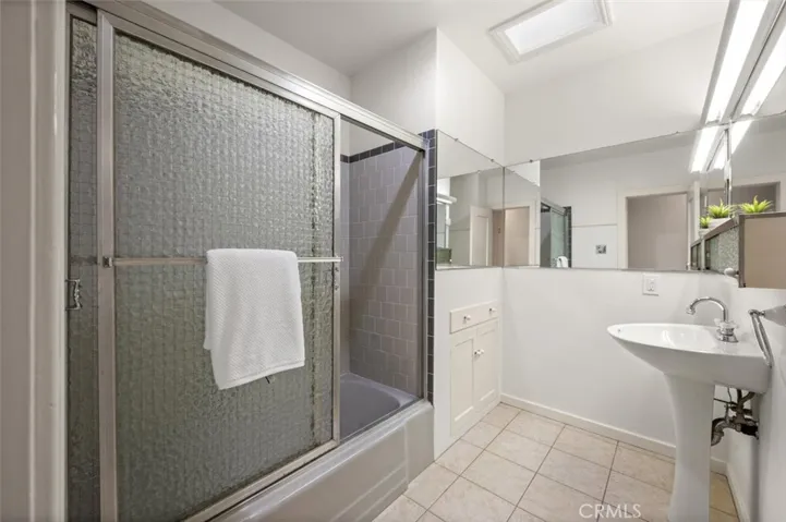 Hall bath with tub & shower and skylight.