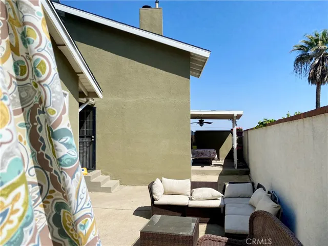 Side patio area with portable fire pit, and covered area at rear with picnic table