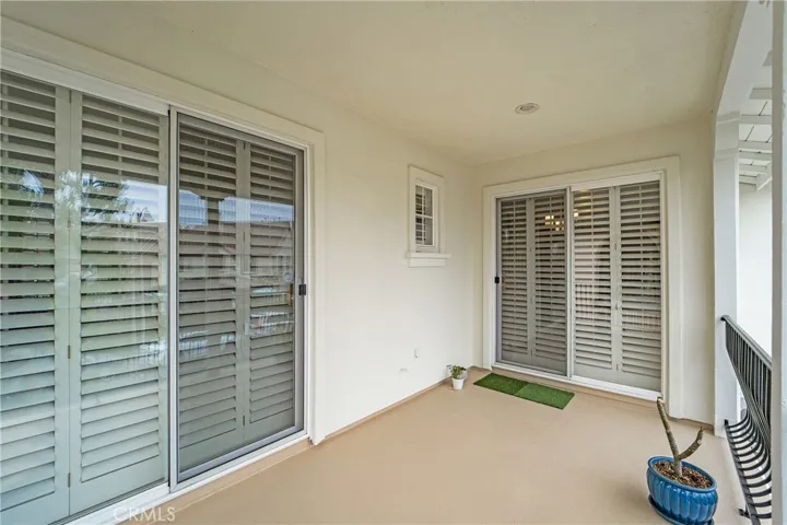 Large balcony with two separate sets of sliding glass doors that lead out.
