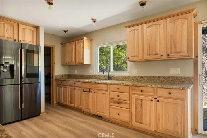 The window view over the sink is the outdoor living area and tree setting.