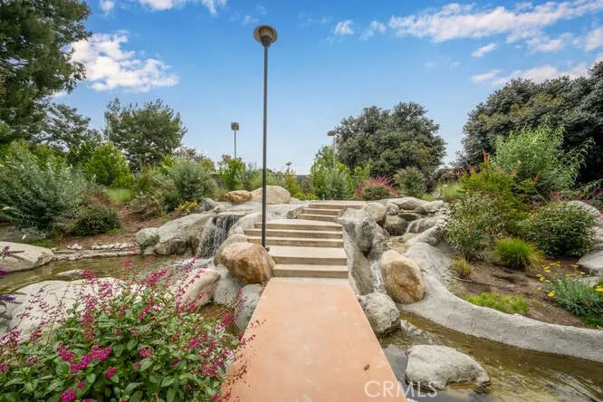 Water features surround each building, pool area, and tennis courts.