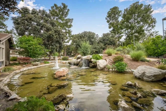 Water features surround each building, pool area, and tennis courts.