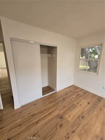 Master Bedroom, hallway in view on the right, one of two closets visible and one of two windows visible