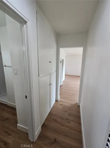 View of Living Room down hallway with Guest Bath and Linen Closets on the left