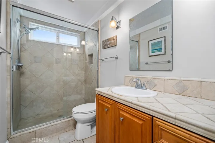 En-suite bathroom with a step-in tile shower and glass door enclosure.