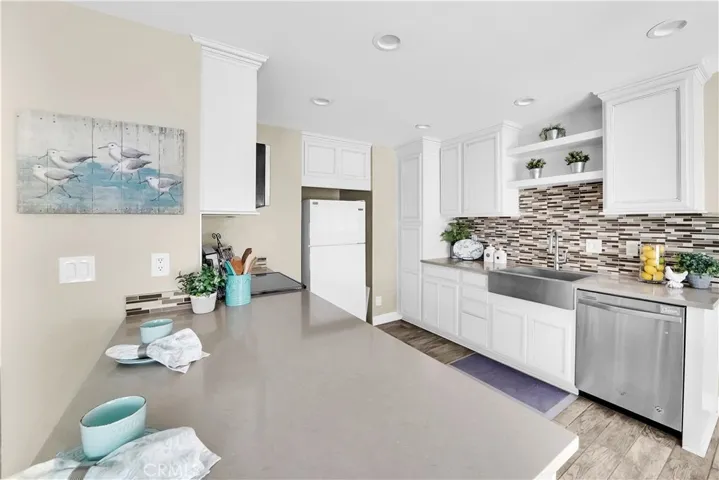 Beautiful back splash, farm sink, recessed lighting, stainless appliances, light and bright kitchen