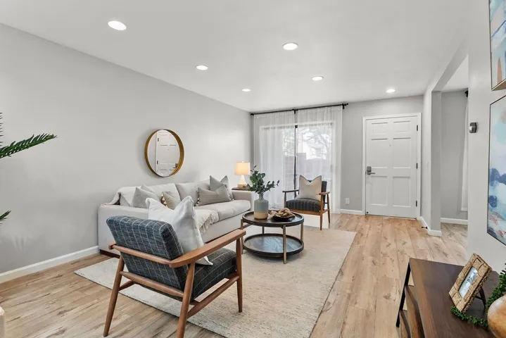 Living room with view of front door and sliding door to patio.
