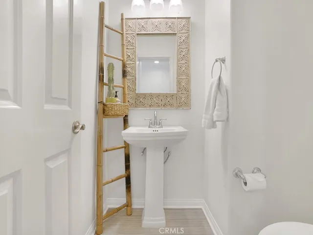 Downstairs 1/2 bath across from the dining room with space-saving pedestal sink and toilet
