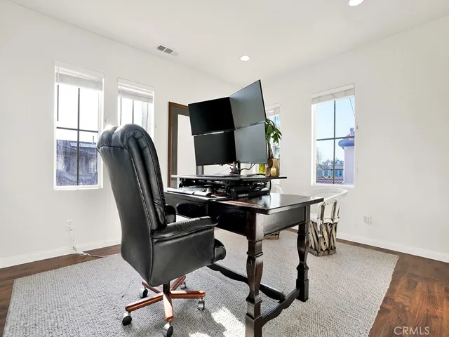 view from the office with all the natural lighting, beautiful flooring, wood blinds, and recessed lighting.