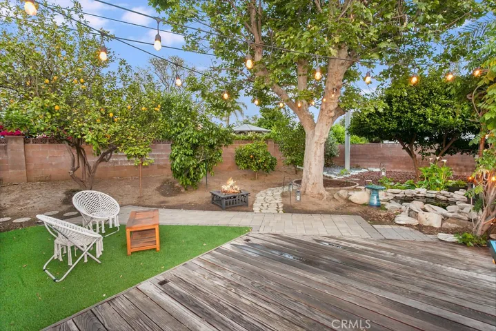 The backyard will be a favorite entertainment destination with its trellis covered patio draped in colorful green foliage, in-ground stone surrounded pond, expansive redwood deck, section of eco-friendly synthetic lawn, colorful planters, towering shade and citrus trees that include lemon, grapefruit and lime, and handy oversized garden/tool/storage shed.