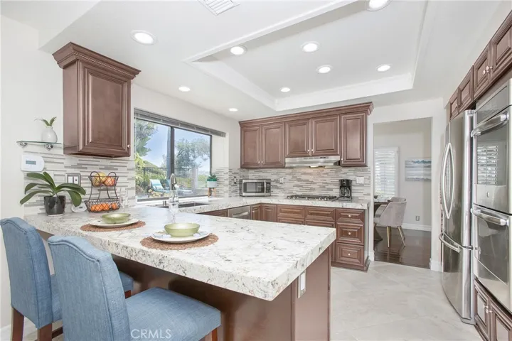 WOW, what a kitchen with 24" tile floors, custom cabinetry, granite counters, and stainless steel appliances, and barstool seating.