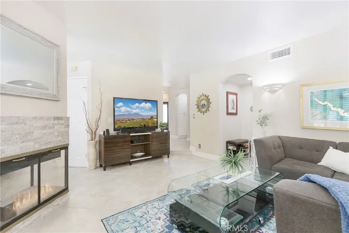 Relax in the spacious family room with 24" tile floors, plantation shutters, and a double-sided fireplace.